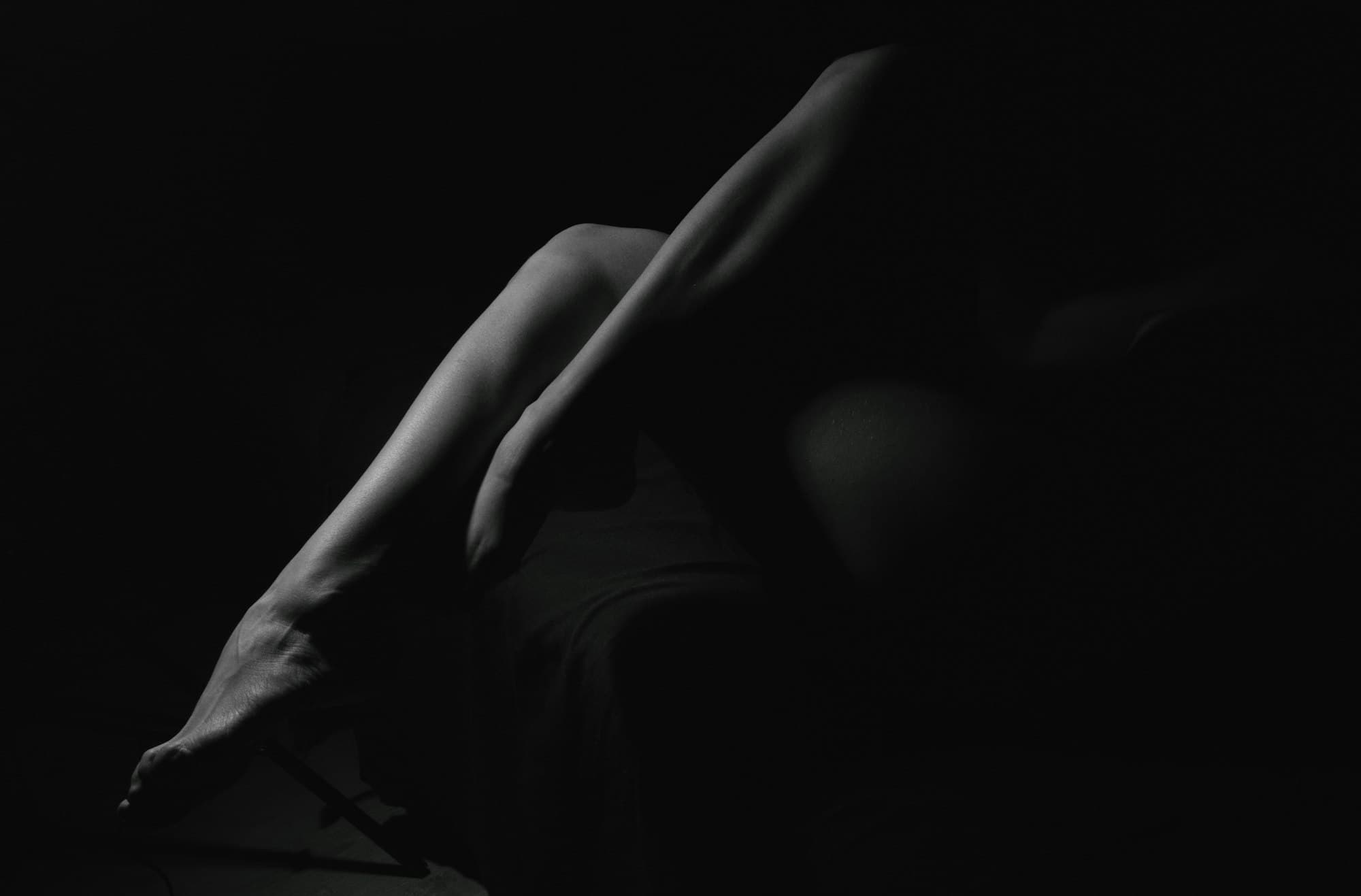 A person lying on a bed in a dark room