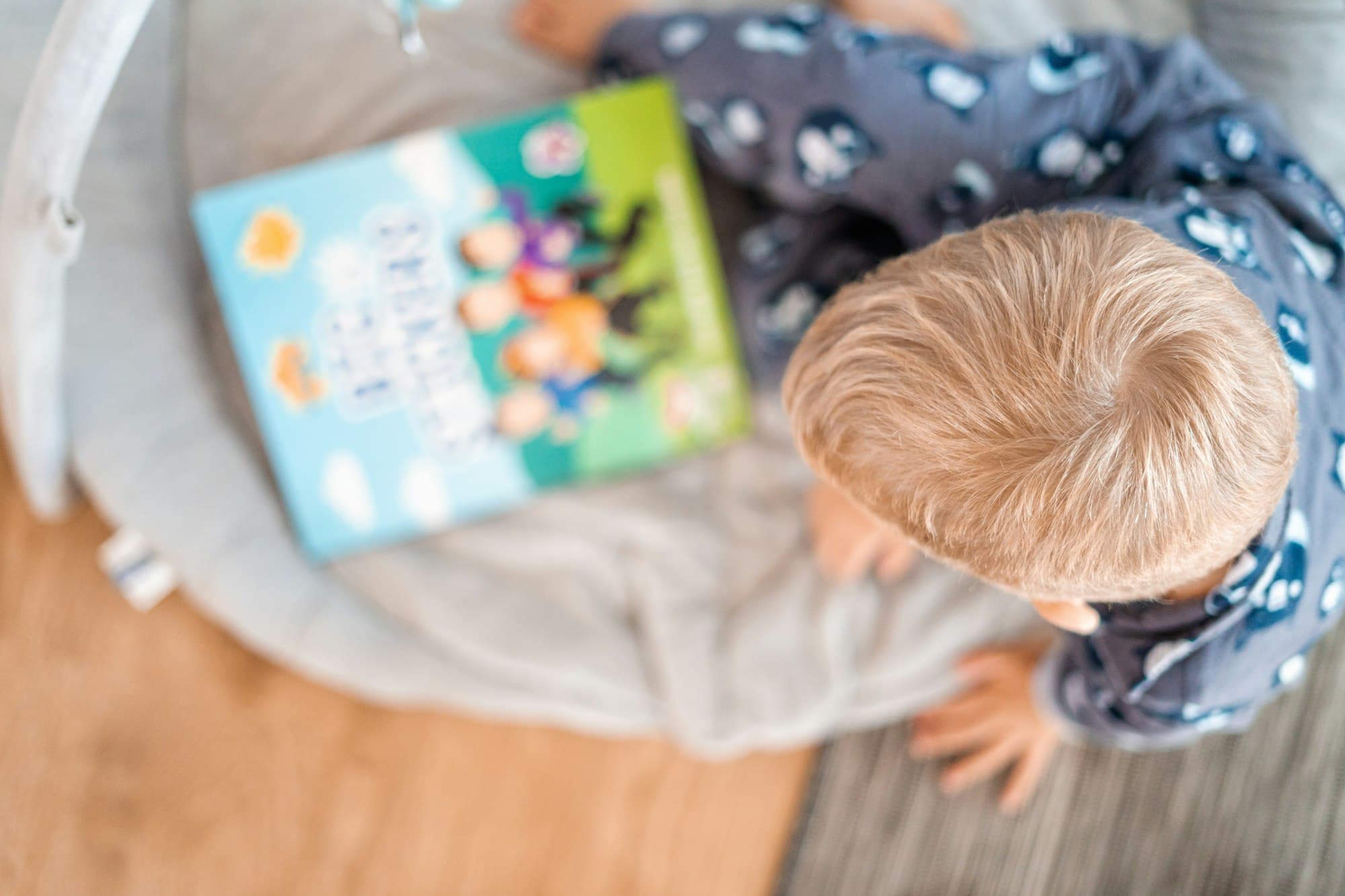 Child reading a book on a bed
