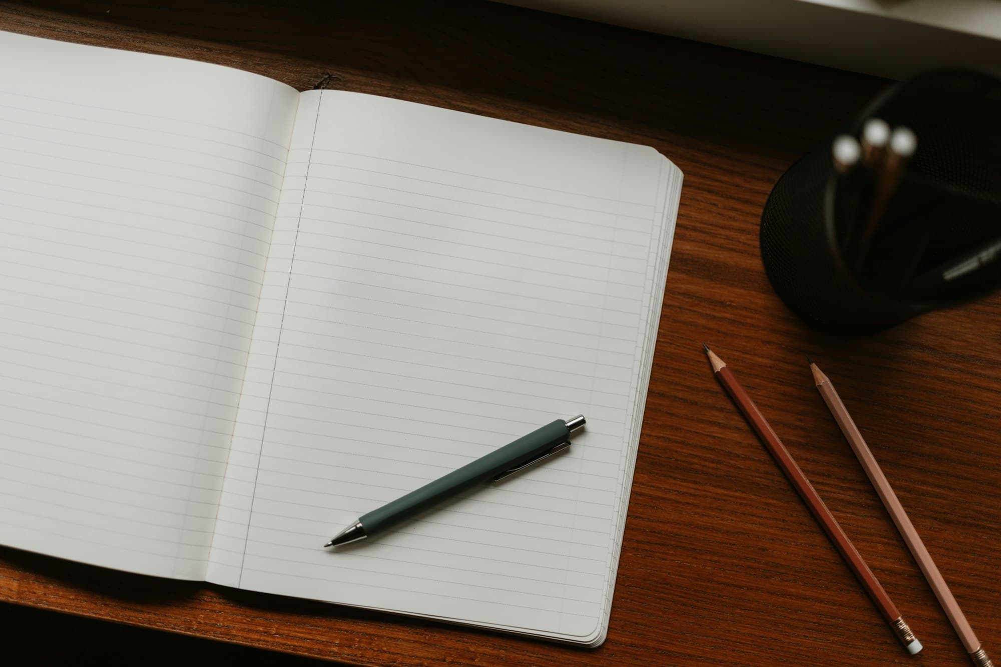 An open notebook with a pen on a desk