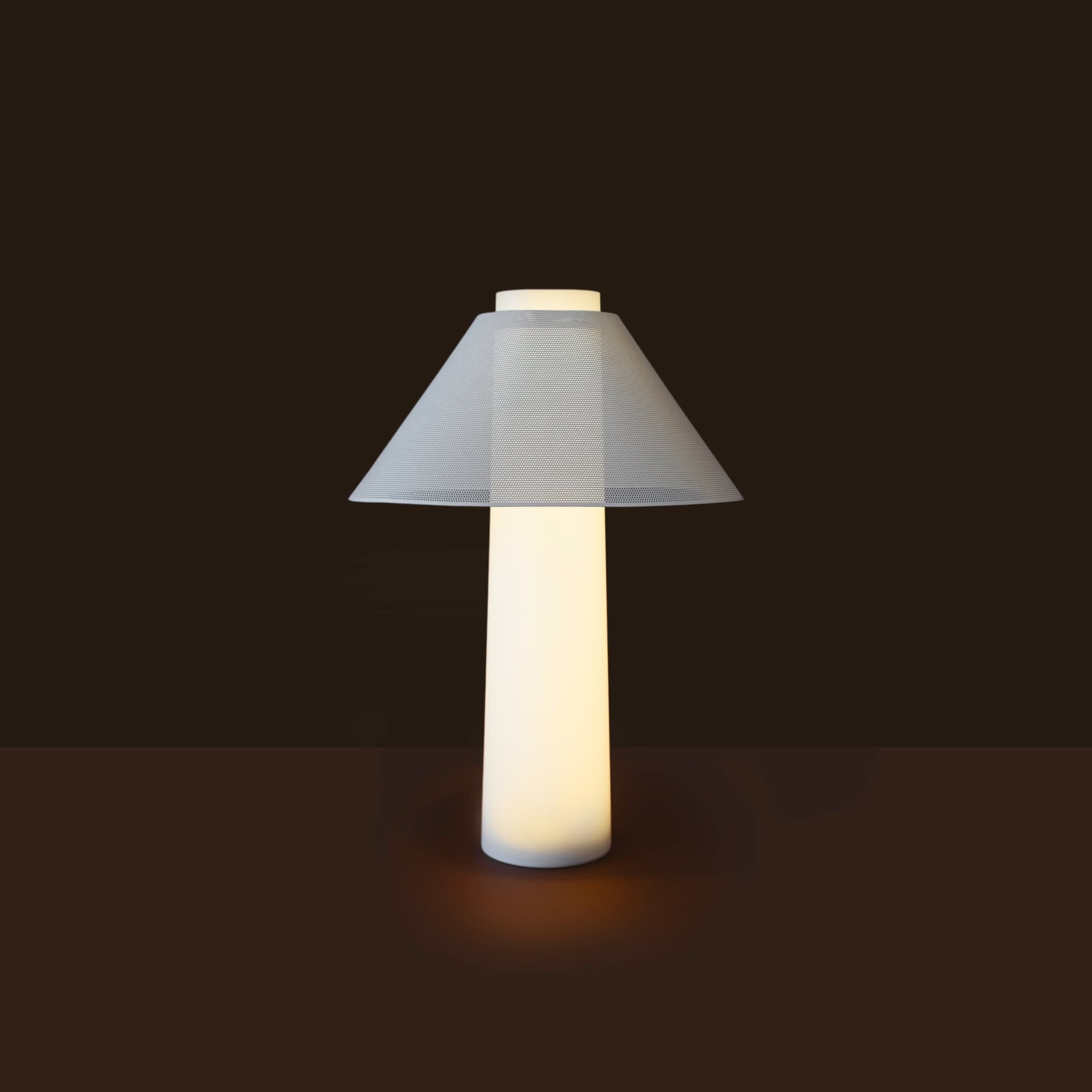Loftie Lamp lit on a dark surface, showing the warm glow through its perforated shade