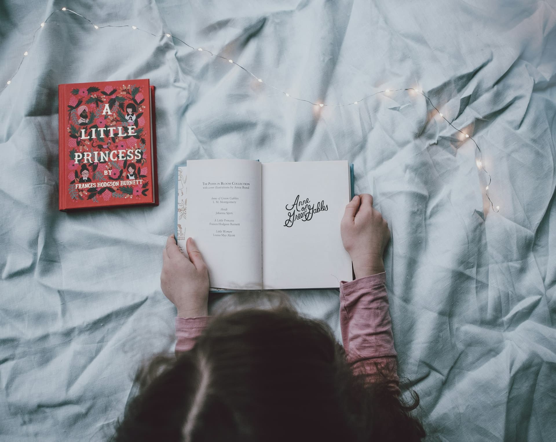 Toddler holding a book on a bed